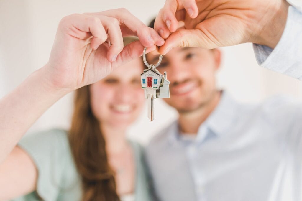 first-time home buyer holding and showing a house key