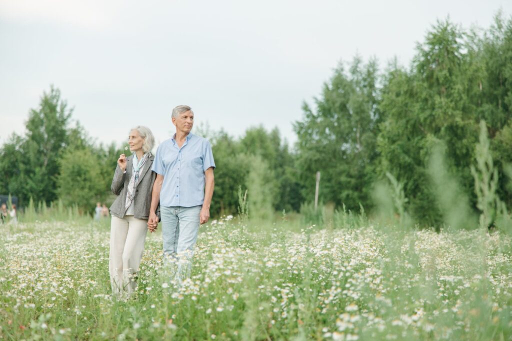 elderly couple walking on a flower field Best Neighborhoods in Lutz for Retirees